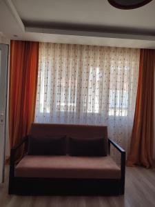 a couch in front of a window with curtains at Umut's Hause in Bezkesen +16 photos
