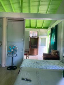 a bedroom with a bed and a living room at Anthurium Apartment in Roseau