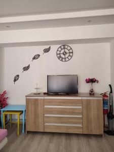 a living room with a tv and a clock on the wall at Umut's Hause in Bezkesen
