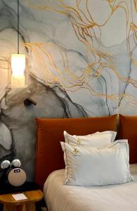 a bedroom with a bed with a wall with a painting at Aux ducs de Sienne in Montagne +75 photos