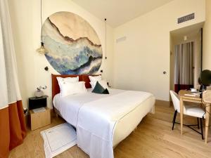 a bedroom with a large white bed and a table at Aux ducs de Sienne in Montagne