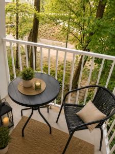 a table and chairs on a balcony with a table and a balcony at Family Spot in Konin