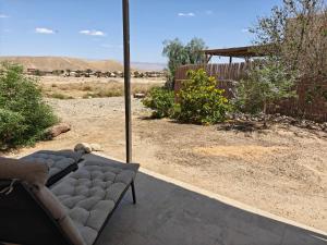 a couch sitting on a patio with a view of the desert at לנשום בצוקים in Zuqim