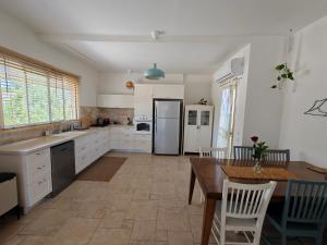 a kitchen with a table and a refrigerator at לנשום בצוקים in Zuqim