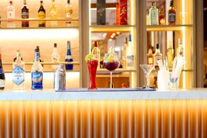 a bar with glasses of wine and bottles of alcohol at Coco Beach Hotel Jomtien Pattaya in Jomtien Beach
