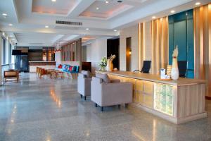 a lobby with a bar with chairs and tables at Coco Beach Hotel Jomtien Pattaya in Jomtien Beach