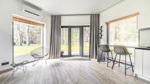 a living room with chairs and sliding glass doors at Beautiful Tinyhouse near the Beach in Lapmežciems