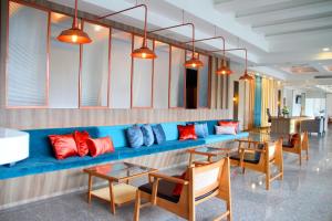 a room with a blue couch with red and blue pillows at Coco Beach Hotel Jomtien Pattaya in Jomtien Beach +56 photos