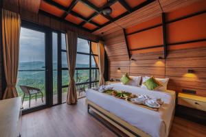 a bedroom with a large bed and a large window at Cliff and Cloud Vagamon in Vagamon +77 photos
