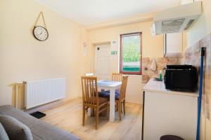 a kitchen and living room with a table and a couch at Guesthouse Kristina in Palić