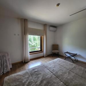 a bedroom with a large bed and a window at Moinho da Ponte Velha in Bragança