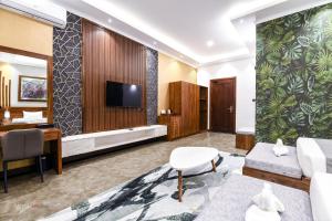 a living room with a couch and a tv and a desk at Madu River Reach in Balapitiya