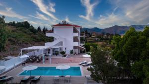 a hotel with a swimming pool and a building at Aspasia Studios in Lixouri