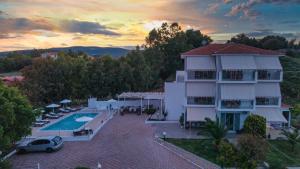 a house with a swimming pool and a sunset at Aspasia Studios in Lixouri