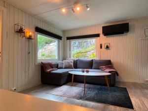 a living room with a couch and a table at Svolvær Minihouse in Kongsmarka