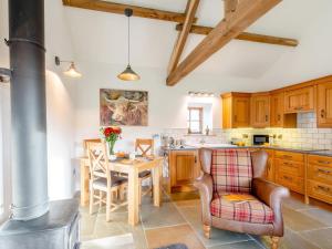a kitchen with wooden cabinets and a table and chairs at 1 Bed in Ripon oc-80303 in Thornton Steward