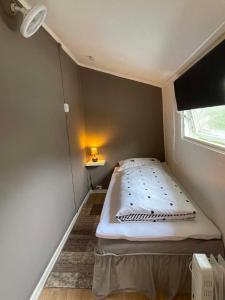 a small bedroom with a bed and a window at Svolvær Minihouse in Kongsmarka