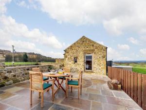 a stone cottage with a table and chairs on a patio at 1 Bed in Ripon oc-80303 in Thornton Steward