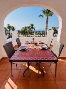 a table with wine glasses on a balcony with palm trees at Bungalows Imperial Park Unitursa in Calpe