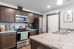 a kitchen with stainless steel appliances and wooden cabinets at Destiny Cove in Kalispell +17 photos