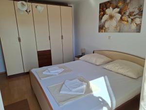 a bedroom with a bed with towels on it at Apartmani Dijana in Rab