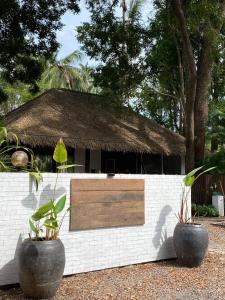 two large pots sitting in front of a building at Arunta Samui in Lipa Noi