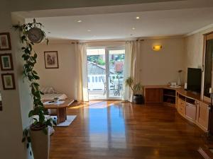 a living room with a wooden floor and a sliding glass door at Apartmani Dijana in Rab