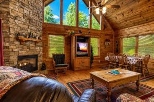 a living room with a fireplace and a table at Cub Crossing, Free Attraction Tickets, Hot Tub, Pool Table, WIFI!!! in Sevierville +26 photos