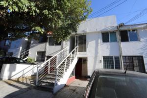 a white house with a staircase in front of it at Departamento en el corazón de angelópolis in Puebla