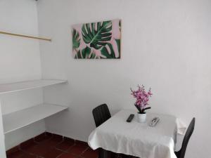 a white table with chairs and a vase of flowers on it at Finca Hotel La Playa Villeta in Villeta