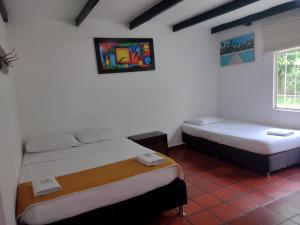 a bedroom with two beds and a window at Finca Hotel La Playa Villeta in Villeta +25 photos