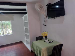 a room with a table and a fan on the wall at Finca Hotel La Playa Villeta in Villeta