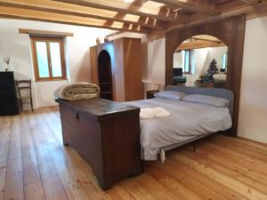 a bedroom with a large bed and a wooden floor at La Baita nel Bosco in Berzo
