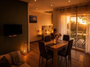 a living room with a dining room table with chairs and a television at L'Ardétente - Le Cocon, Piscine et Spa en Ardèche, Adults Only in Lussas