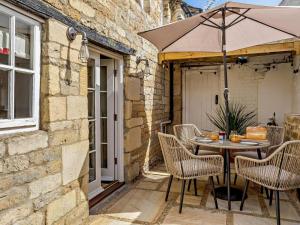 a table and chairs with an umbrella on a patio at 1 Bed in Stamford oc-92406 in Ketton
