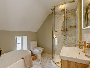 a bathroom with a tub and a toilet and a sink at 1 Bed in Stamford oc-92406 in Ketton +16 photos