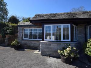 a small brick house with windows on a driveway at 1 Bed in Swanage oc-dc098 in Swanage