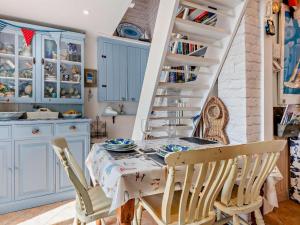 a dining room with a table and chairs and a staircase at 1 Bed in Lymington oc-94751 in Lymington +7 photos