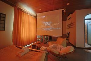 a living room with a projection screen and two chairs at Àla Homestay Cần Thơ in Can Tho