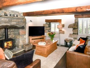 a living room with a fireplace and a stone wall at 2 Bed in Lancaster oc-91411 in Clapham