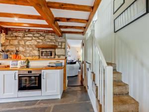 a kitchen with white cabinets and a stone wall at 2 Bed in Lancaster oc-91411 in Clapham