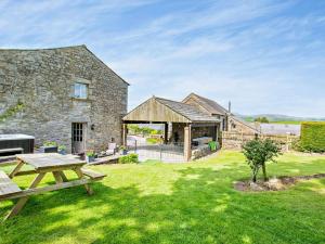a stone house with a picnic table in the yard at 2 Bed in Lancaster oc-91411 in Clapham
