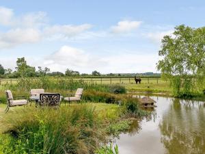 two chairs and a table next to a pond at 1 Bed in Aylesbury oc-76403 in Ludgershall