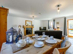 a wooden table with plates and glasses on it in a living room at 1 Bed in Lydney oc-43724 in Lydney