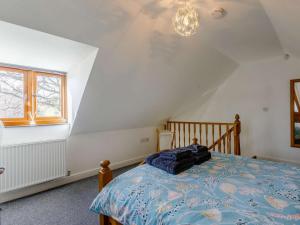 a bedroom with a bed with a blue comforter at 1 Bed in Lydney oc-43724 in Lydney