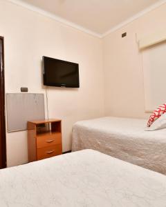 a room with two beds and a flat screen tv at Hotel Vista Hermosa 17 in Viña del Mar