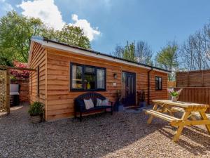 a small wooden cabin with a picnic table and a bench at 2 Bed in Ashbourne oc-81345 in Clifton