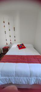 a large white bed with a red blanket on it at Pukari Hotel Cusco in Cusco