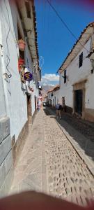 a cobblestone street in a town with buildings at Pukari Hotel Cusco in Cusco