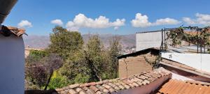 a view of the roofs of buildings with mountains in the background at Pukari Hotel Cusco in Cusco +6 photos